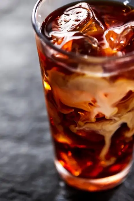Iced cold brew with sweet cream swirling in the glass