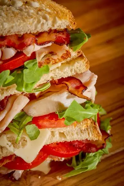Stacked turkey, bacon and arugula sandwich
